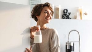 lady smiling with bottle of milk on her hand